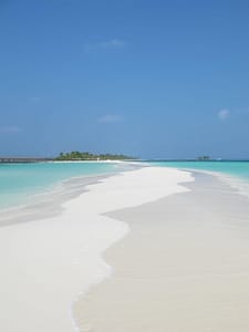 Banc de sable bordé d'un lagon turquoise au Kuredu Island Resort, aux Maldives.